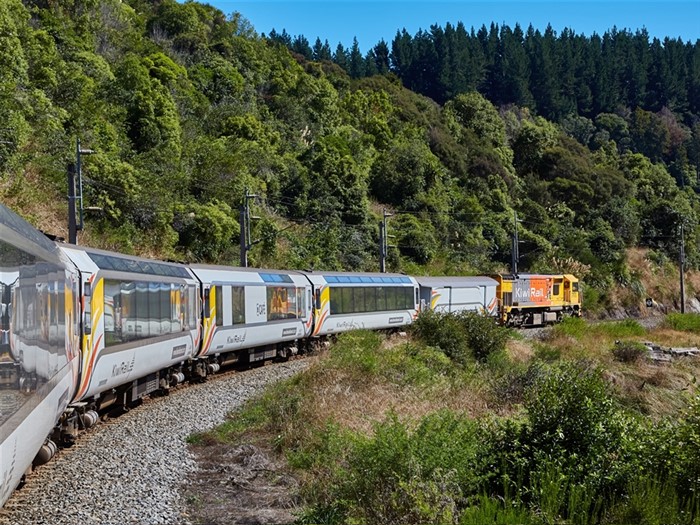 KiwiRail scenic train travelling through forested hills in New Zealand